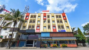 A multi-story building with a prominent red and yellow facade, featuring a sign for 'Comfort Executive' and 'Fab Hotels'. - DE COMFORT EXECUTIVE (Paud)