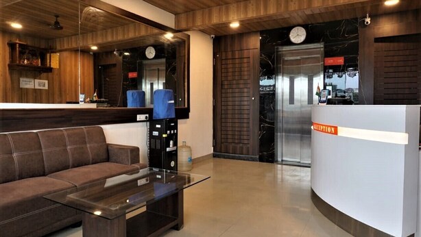 A reception area with a sofa, a glass table, and a reception desk. - DE COMFORT EXECUTIVE (Paud)
