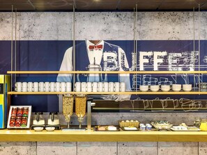 A buffet counter with a variety of food items, including fruits, pastries, and beverages. - B&B Hotel Köln-porz (Cologne)