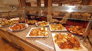 Balcão de buffet com diversos tipos de comida.