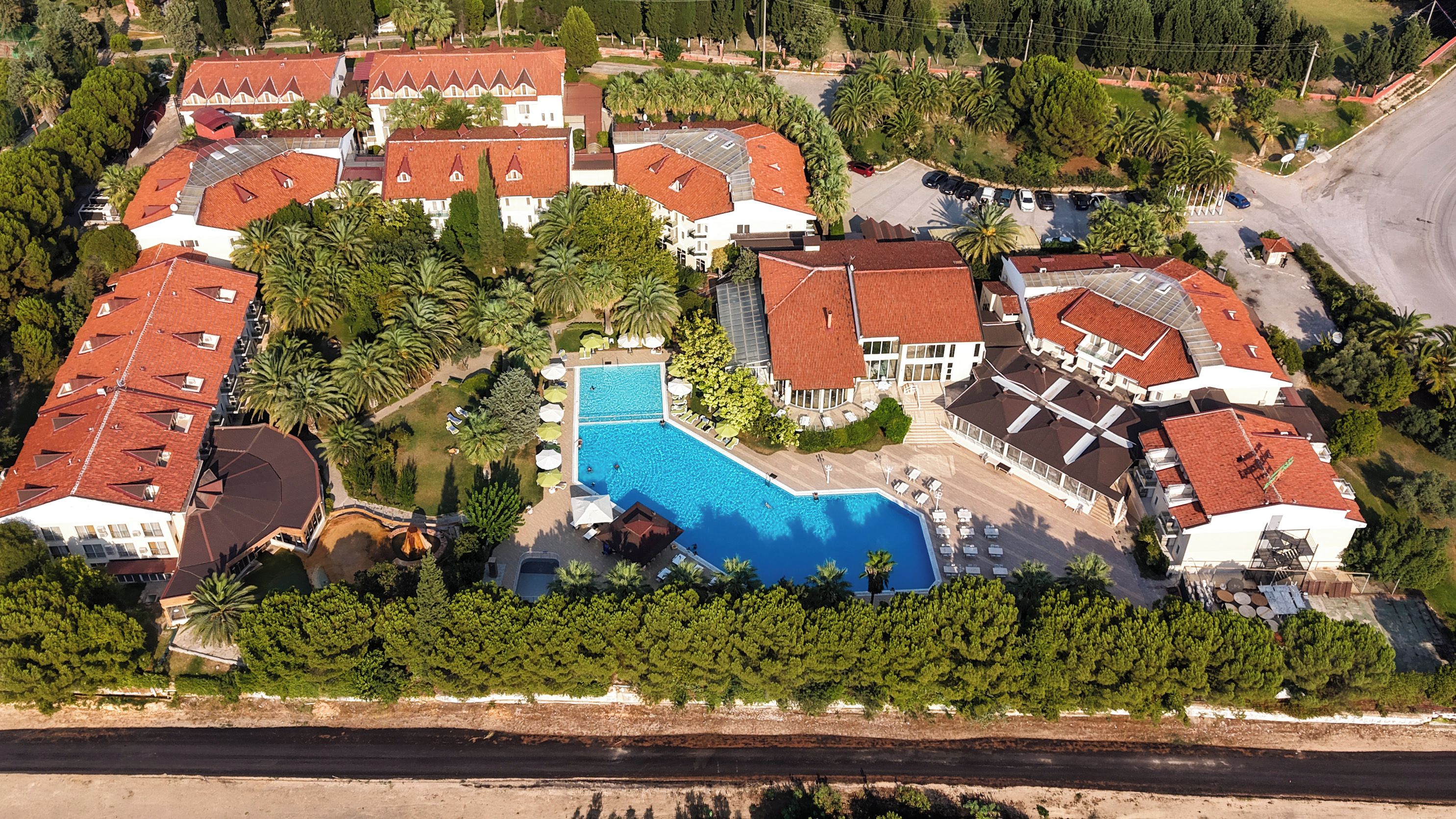 Vista aérea de um bairro residencial com várias casas, uma piscina e vegetação ao redor.