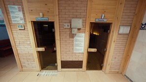 Three wooden doors labeled 'Fin Hamami,' 'Sauna,' and 'Sauna,' with a ventilation grate in front. - Lycus River Thermal Hotel (Denizli)