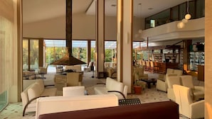 A spacious lobby with high ceilings, large windows, and a central column. There are multiple seating areas with sofas and chairs. - Lycus River Thermal Hotel (Denizli)