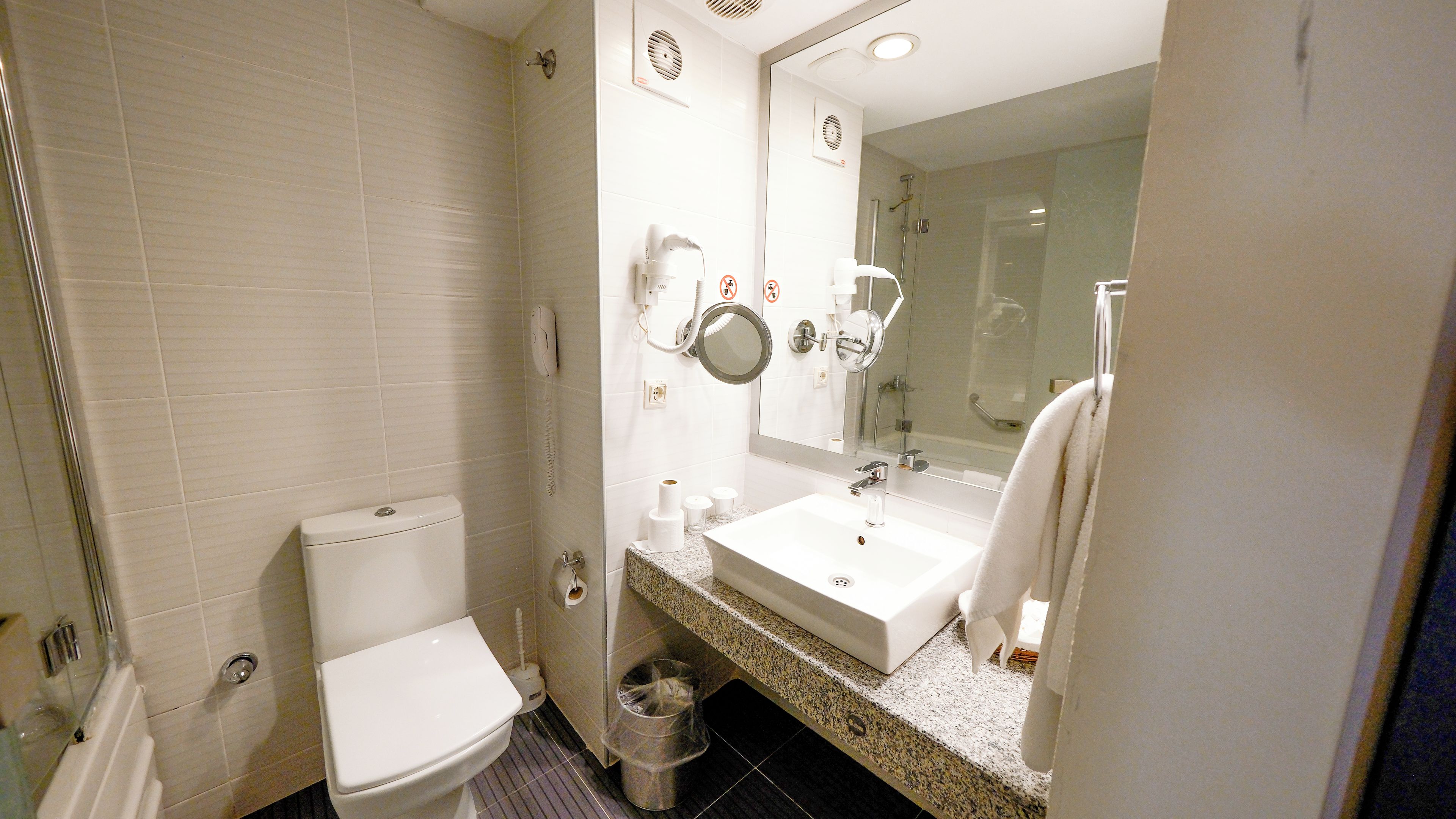 Un baño con inodoro, lavabo y espejo.