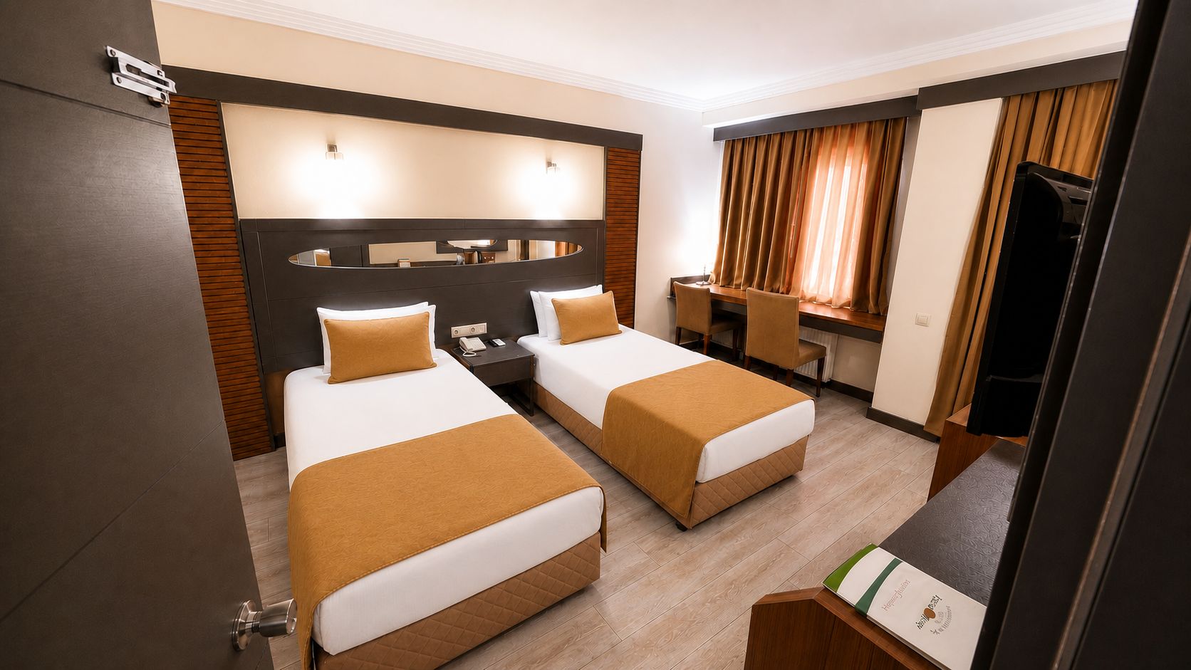 Una habitación de hotel con dos camas, un escritorio, un televisor y un espejo.