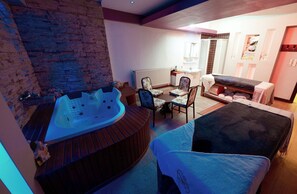 A spa room with a hot tub, a massage table, and a seating area with chairs. - Lycus River Thermal Hotel (Denizli)