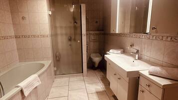 Ein modernes Badezimmer mit Badewanne, Dusche, Toilette und Waschtisch.