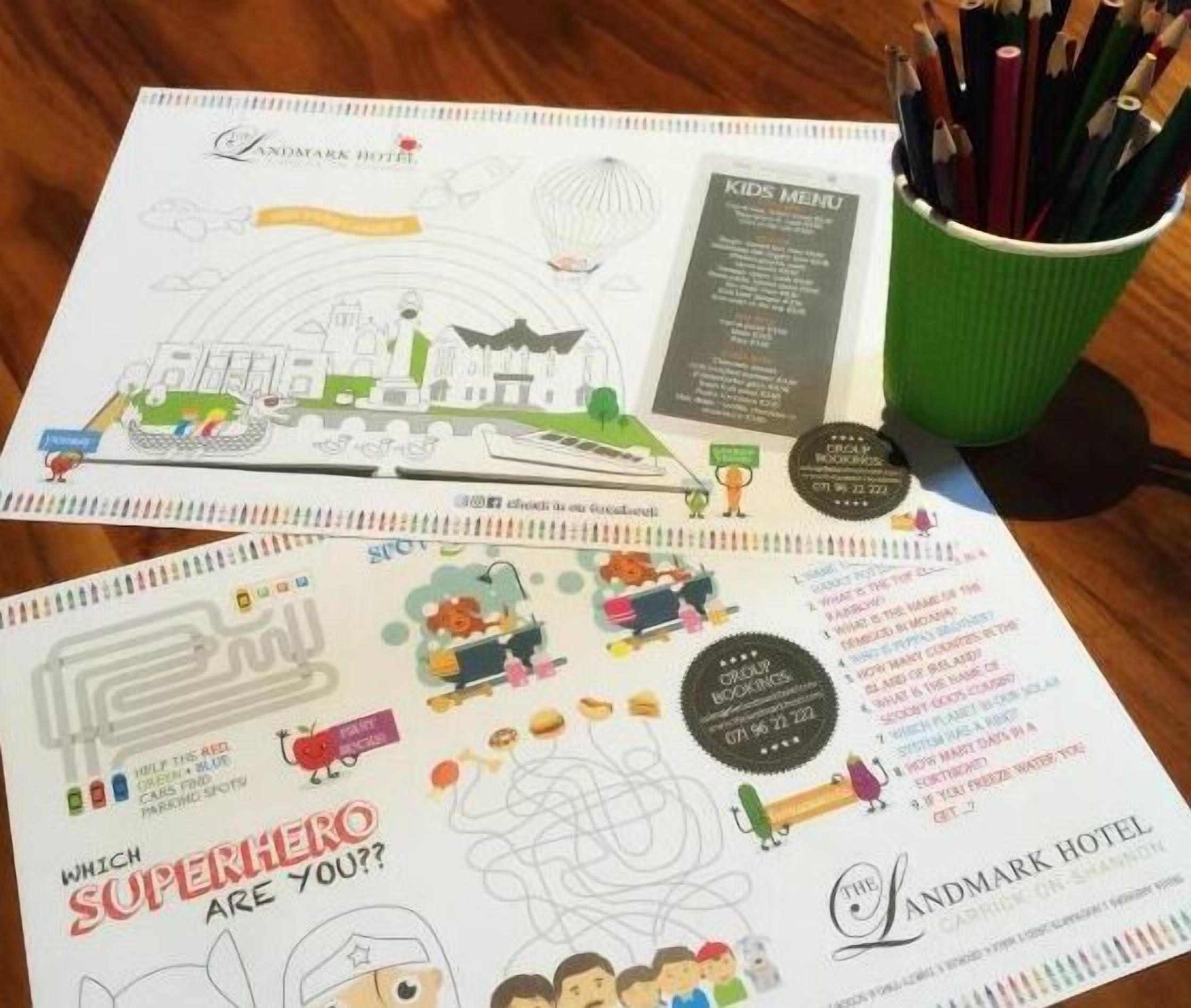 Un llibre d'activitats per a nens amb il·lustracions i text, un suport per llapis amb llapis de colors i un menú infantil.