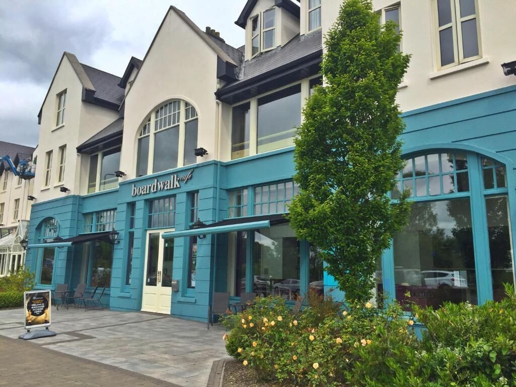 Un edificio de dos pisos con un letrero que dice "boardwalk cafe".