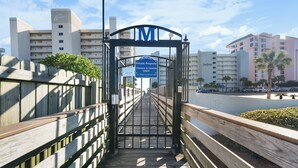 Pasarela de madera que conduce a una entrada con puerta, con un letrero que dice 'Solo propietarios e invitados'.