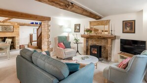 A cozy living room with a stone fireplace, a television, and comfortable seating. - Newly Refurbished Cosy Cottage in the Heart of Chipping Campden (Chipping Campden)