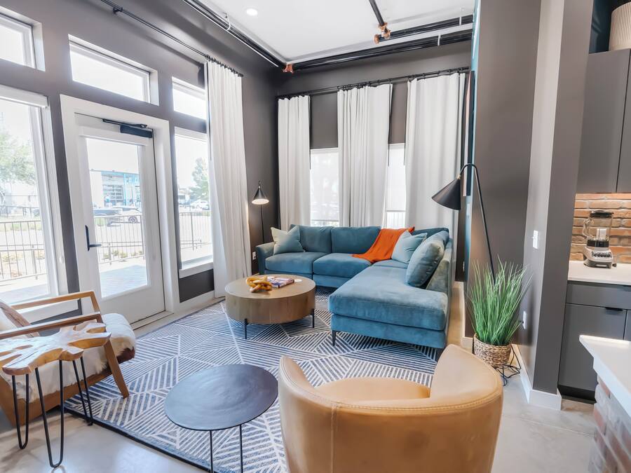 A modern living room with a sectional sofa, a round coffee table, and a patterned rug.