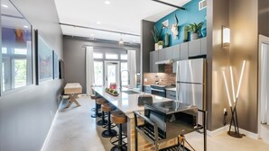 Een moderne keuken met een centraal eiland, een paar barkrukken en een inbouwoven.