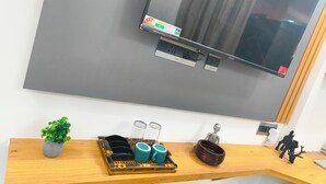 A modern kitchen with a large flat-screen TV mounted above a wooden countertop.
