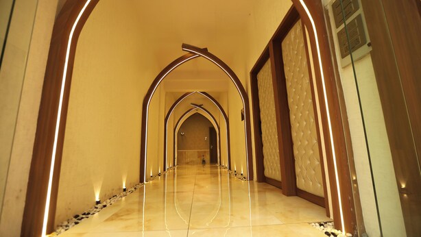 A hallway with a series of arches and a polished floor. - Hotel Reyansh Pride (Palghar)