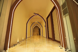 A hallway with a series of arches and a polished floor.