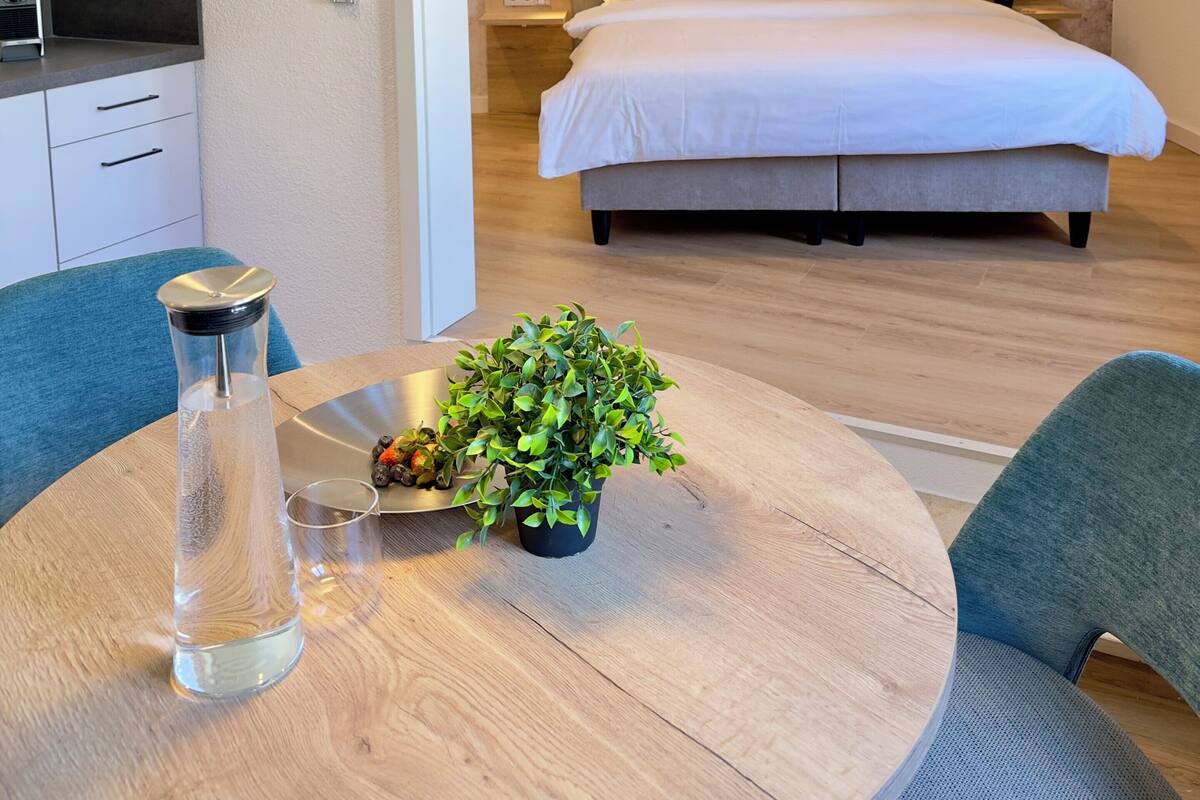 Een moderne slaapkamer met een bed, nachtkastje en een kunstwerk aan de muur.