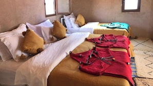 A room with two beds, each with white and brown bedding. There are windows on the walls, and a lamp hanging from the ceiling. - Sahara vibes luxury camp (Rissani)