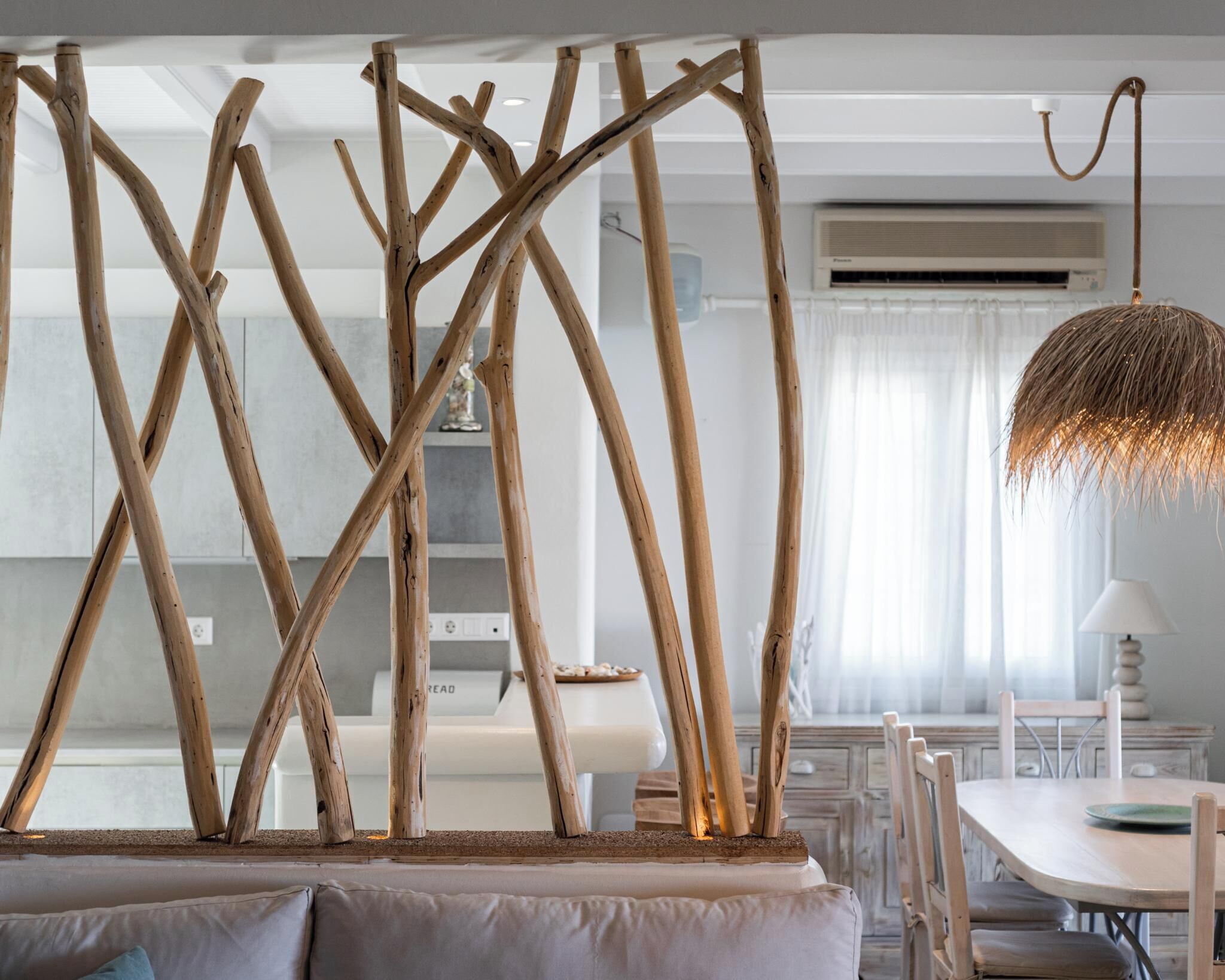 Una cocina moderna con una isla central, detalles de madera y un comedor con mesa y sillas.