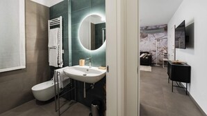 Ein modernes Badezimmer mit Toilette, Waschbecken und Spiegel.