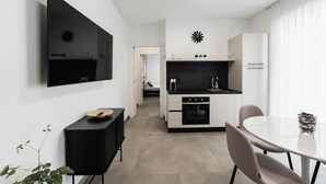 Eine moderne Küche mit schwarzer Arbeitsplatte, weißen Schränken und einem eingebauten Backofen.