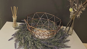 A table with a geometric wire basket, a glass vase with dried flowers, and a container of incense sticks. - Central London Studio for 2 with Kitchenette (London)