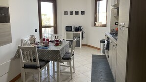 Eine kompakte Küche mit Essbereich, ausgestattet mit einer Mikrowelle, einem Herd und einem kleinen Kühlschrank.