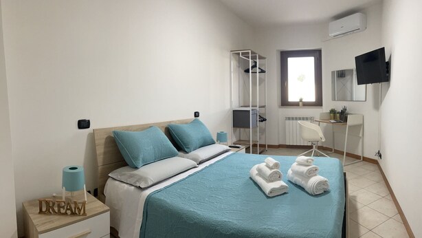 Ein ordentlich eingerichtetes Schlafzimmer mit Bett, Schreibtisch und Stuhl.