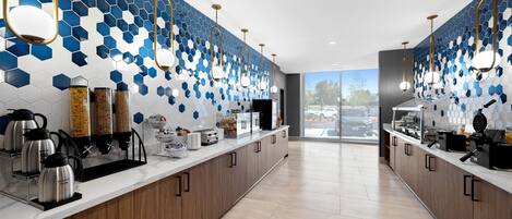 Una cocina moderna con una encimera larga, salpicadero de azulejos hexagonales y electrodomésticos de acero inoxidable.