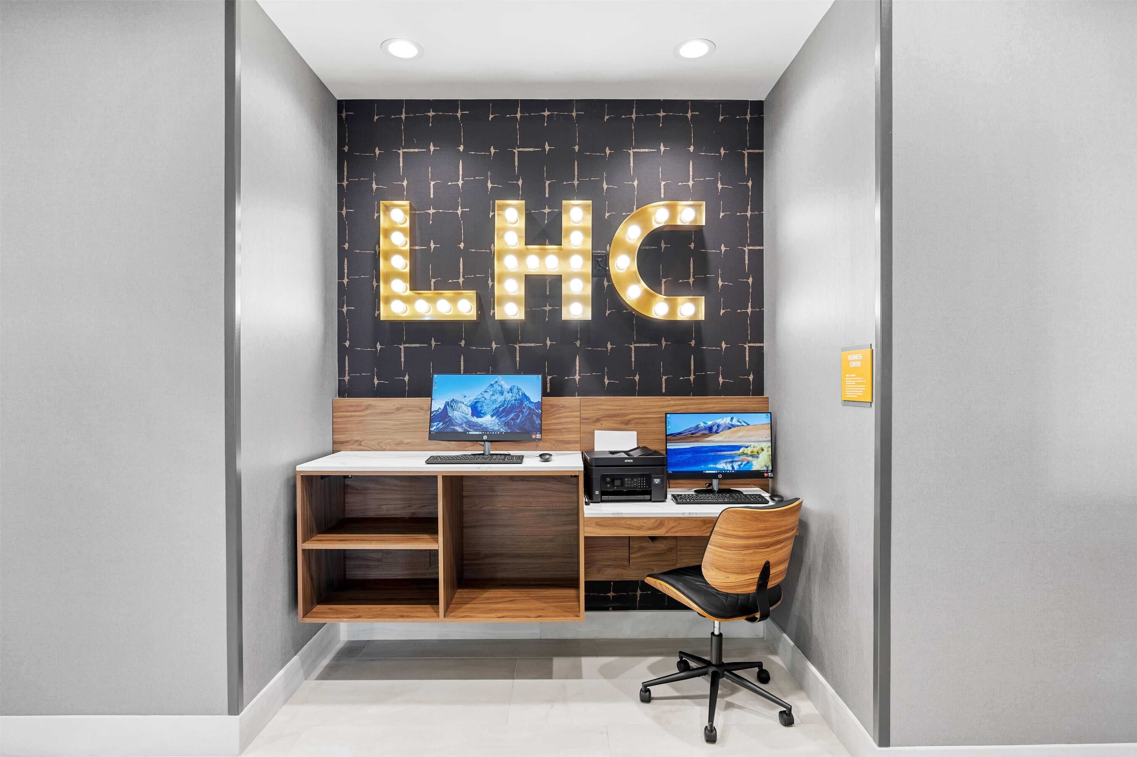 A modern office space with a desk, computer, and a chair.