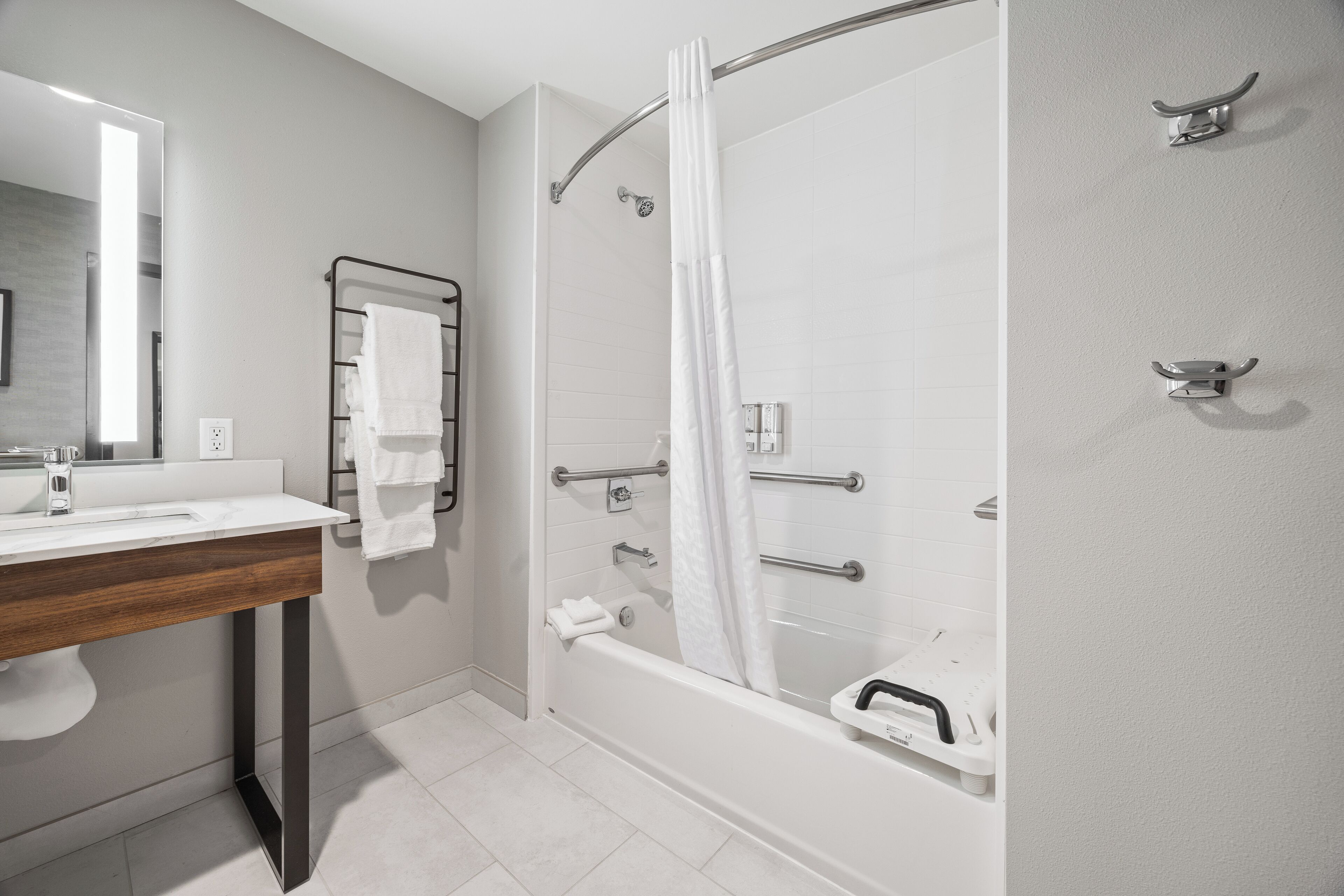 Un baño moderno con ducha, lavamanos y espejo.