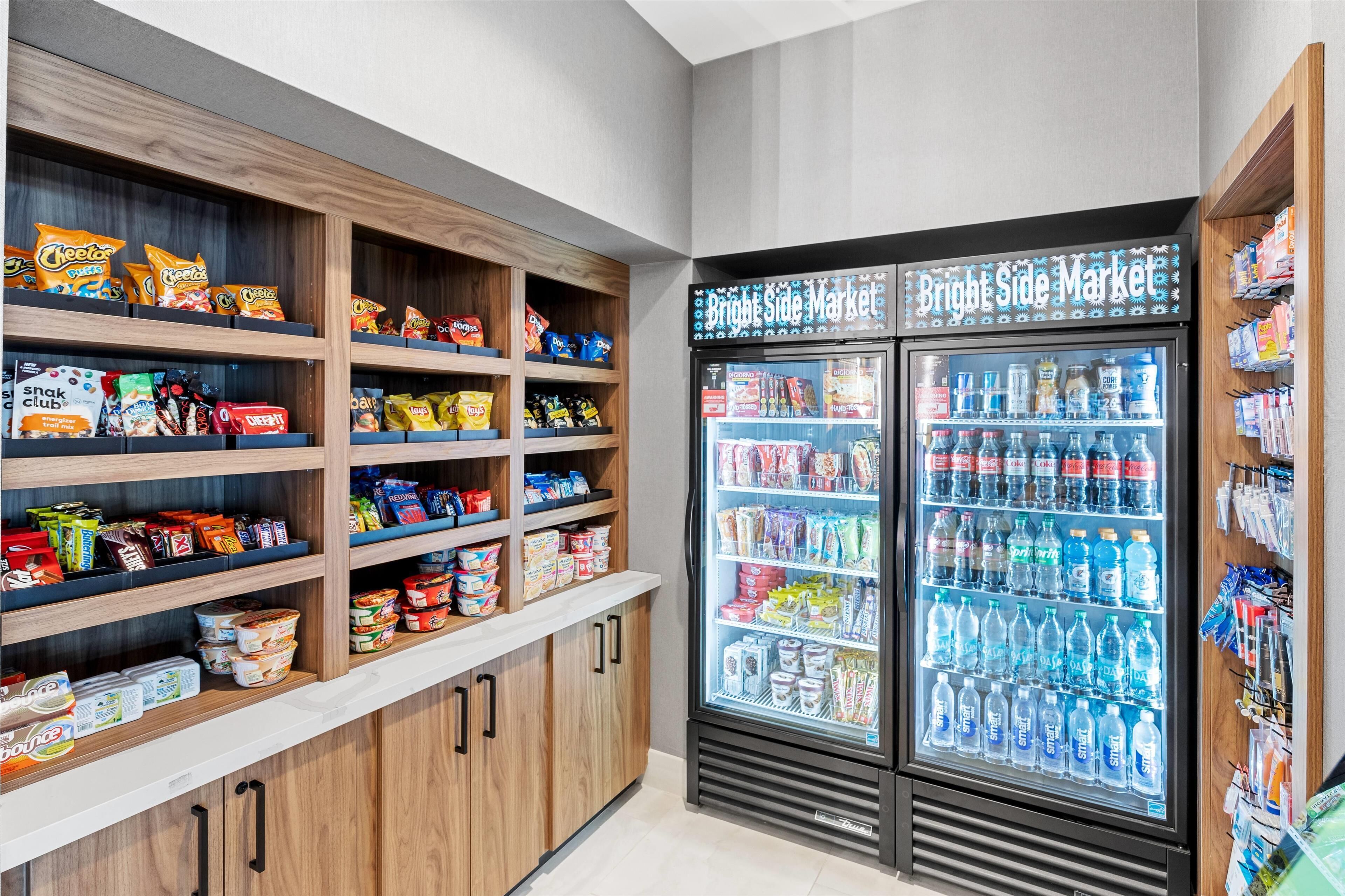 A snack and beverage section with shelves of chips, snacks, and a refrigerated display of bottled water and sports drinks.