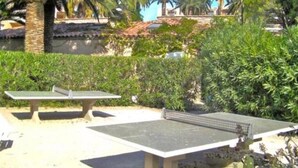 An outdoor ping pong table set up in a garden with palm trees and dense foliage in the background. - T2 A/C côte d'Azur, piscine, plage á 350m, WIFI  (Vallauris)