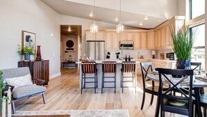A modern kitchen with wooden cabinets, stainless steel appliances, and a central island with bar stools.