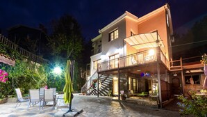A two-story building with a balcony and outdoor seating area. - Chalet Pinecone by Ezoria Villas (Platres)