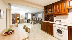 A compact living space with a dining area, kitchen, and a living room.