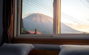 Una habitación con un gran ventanal con vistas a la montaña.