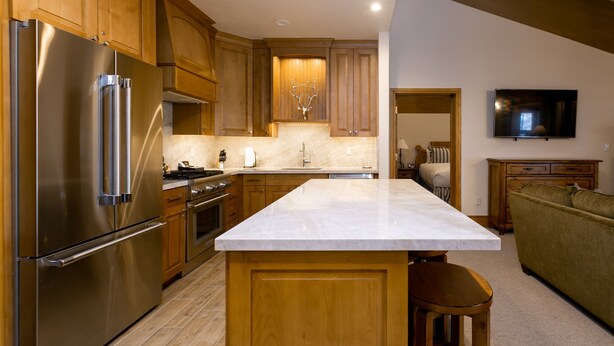 A modern kitchen with wooden cabinets, stainless steel appliances, and a marble countertop. - Luxury Three Bedroom Suite with Three Kings 3 Suite (Park City)