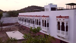 Un edificio con pareti bianche e tocchi di rosso, con numerosi balconi e decorazioni elaborate.