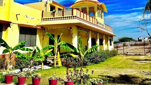 Un edificio giallo con un ampio balcone e una struttura a forma di cupola.