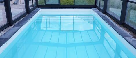 Una piscina cubierta, una piscina al aire libre