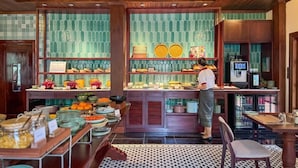 Un buffet proposant une variété de plats et une personne qui sert les clients.