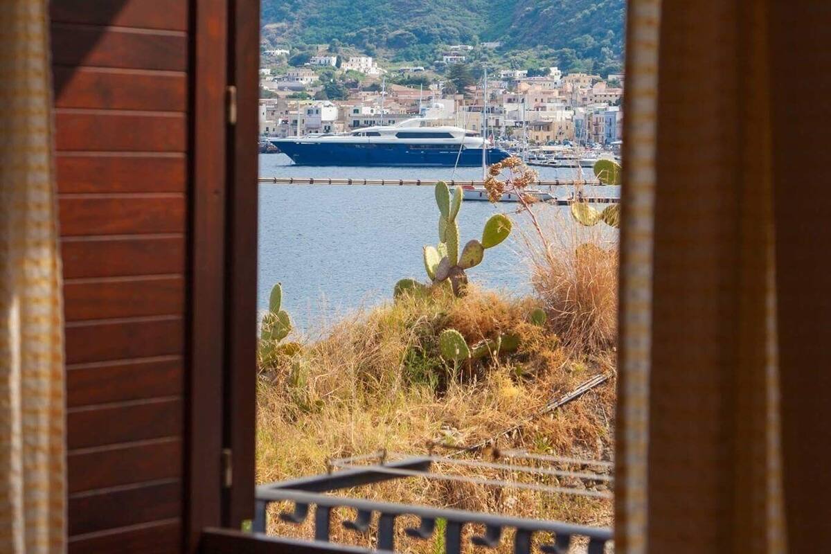 A view from a balcony with a mountain, a body of water, and a cityscape in the background.