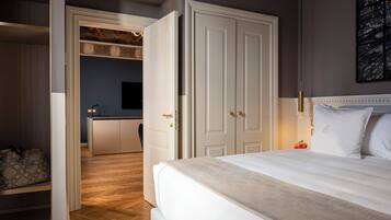 A bedroom with a large bed, a wardrobe, and a desk area with a chair.