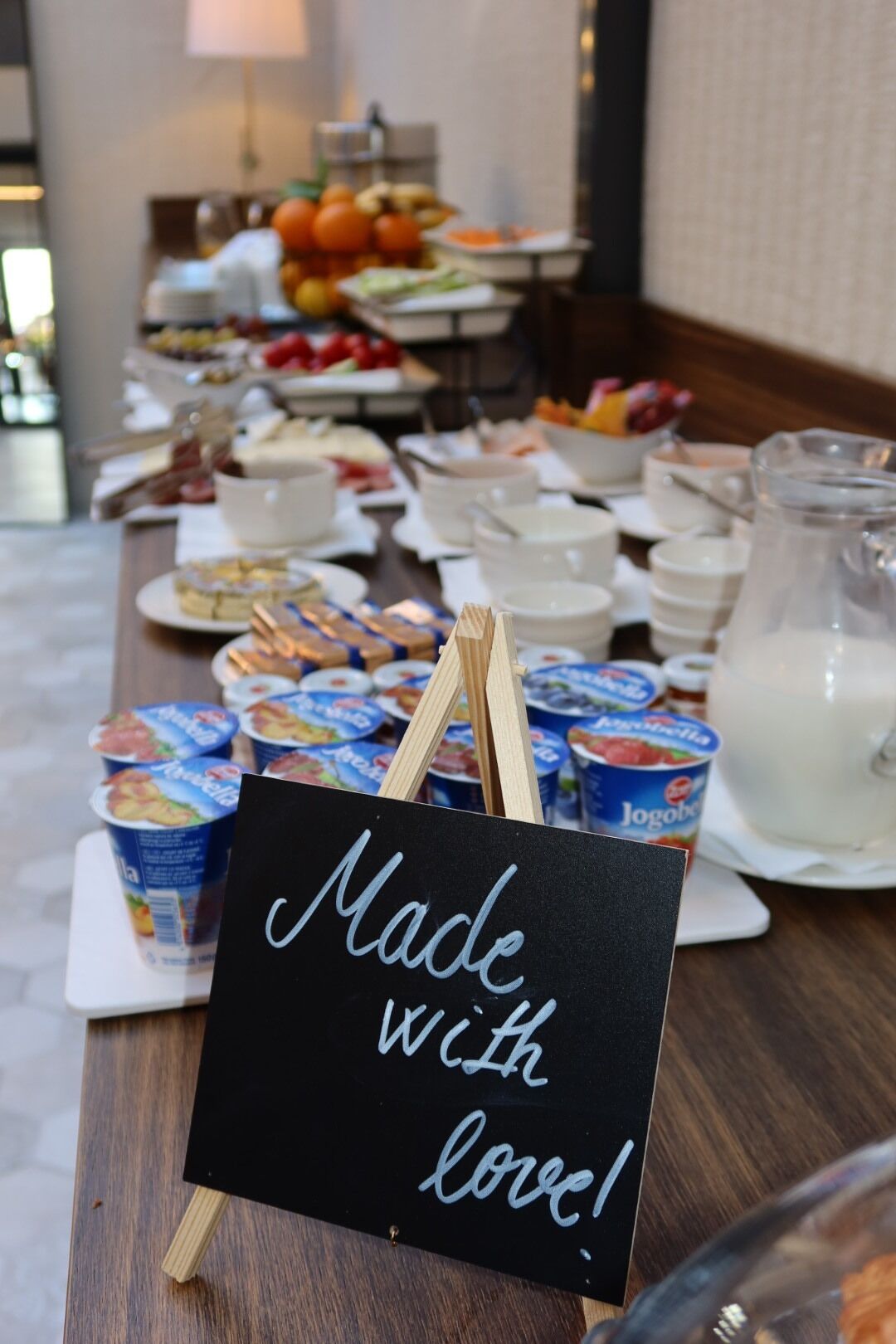 A buffet table with various food items and a sign that reads "Made with love!".