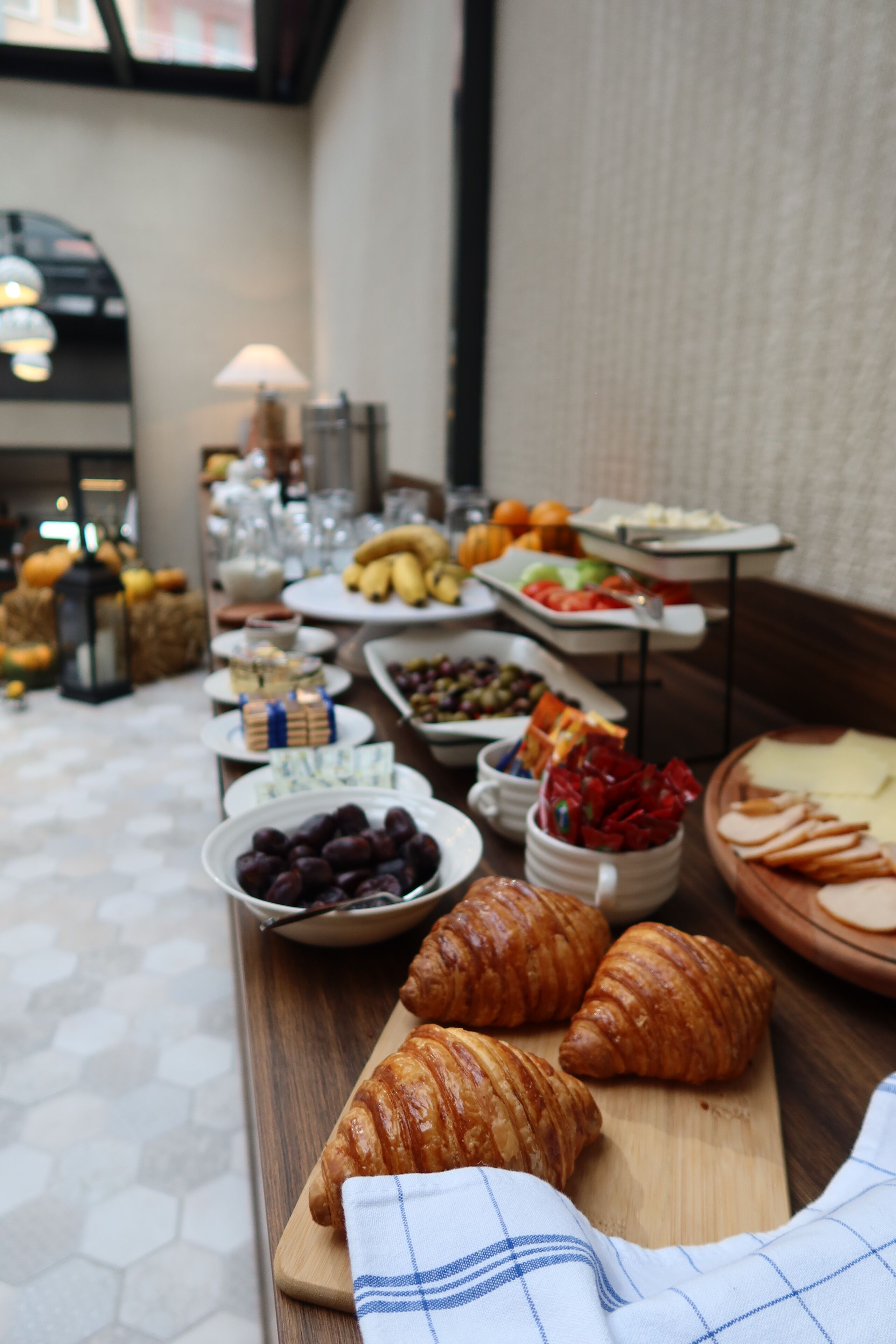A buffet table with various food items including fruits, cheeses, and pastries.