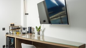 A modern kitchen with a wooden countertop, a built-in refrigerator, and a wall-mounted TV. - Iria Sea View Room (Platanias)