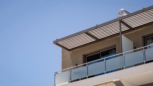A modern building with a balcony, a window, and a clear sky. - Iria Sea View Room (Platanias)
