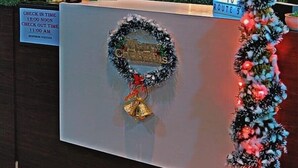 A reception desk with a neon sign reading "Route55" and a Christmas wreath. - Hotel Route 55 (Darjeeling)