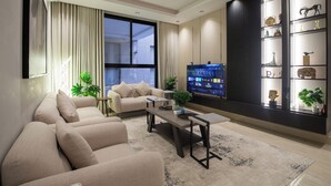 Una sala de estar moderna con un conjunto de sofá, una mesa de centro, un televisor y una estantería.